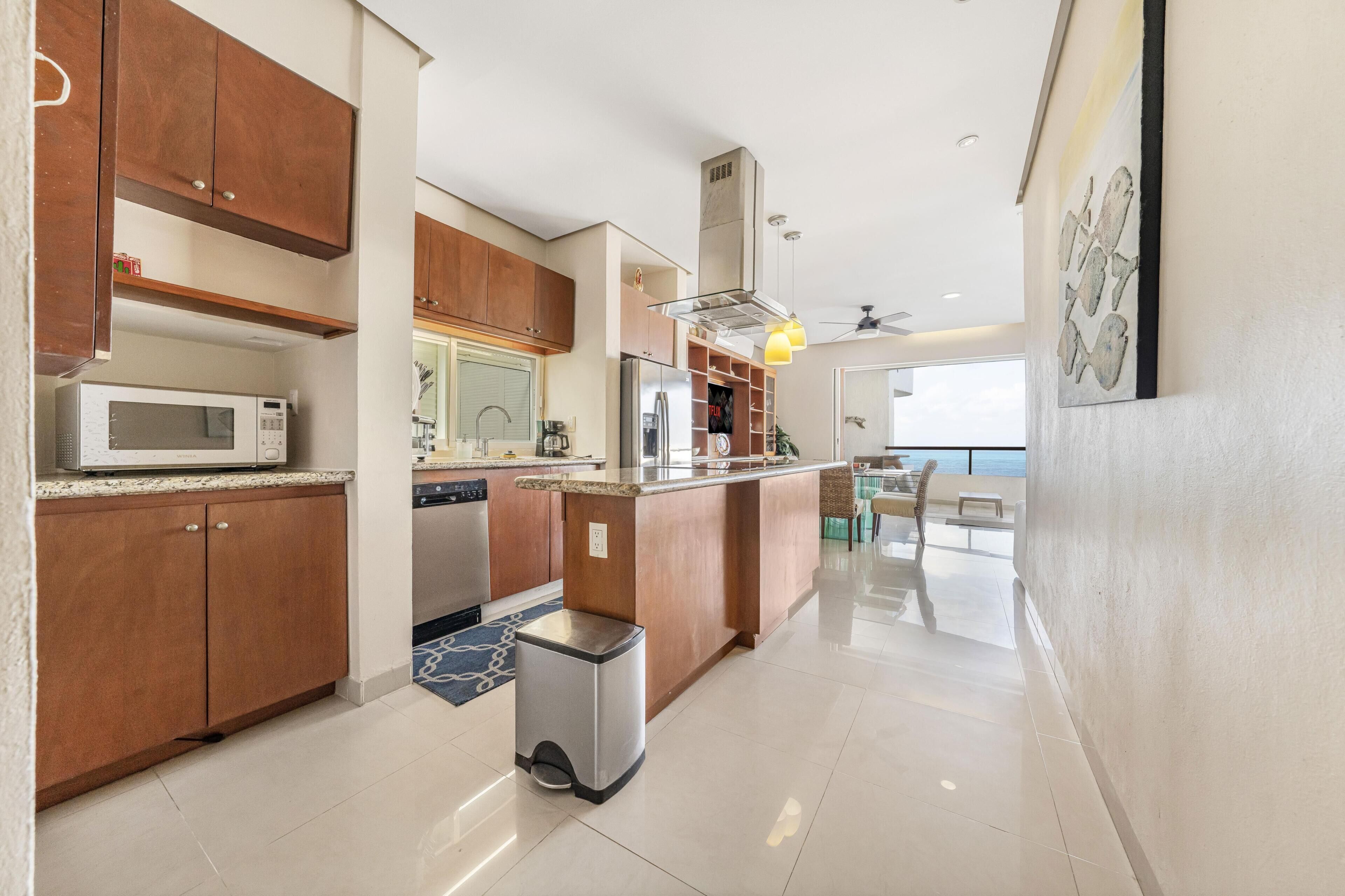A modern kitchen with wooden cabinets, stainless steel appliances, and a built-in island.