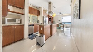 Una cucina moderna con mobili in legno, elettrodomestici in acciaio inossidabile e un'isola integrata.