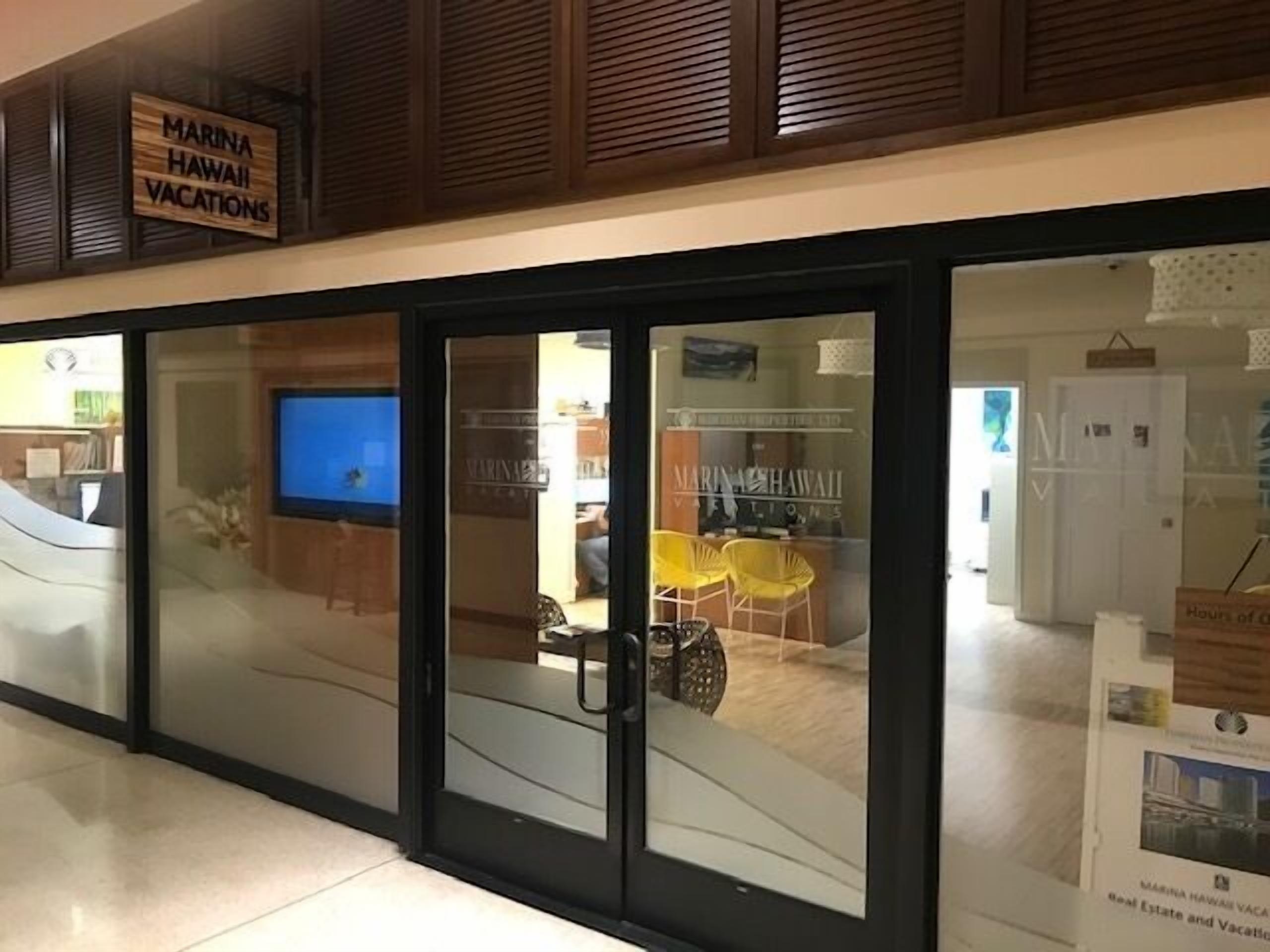 A hotel entrance with a sign reading "Marina Hawaii Vacations".