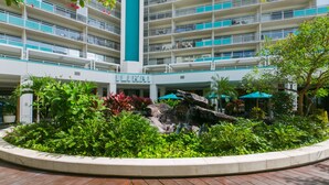 A multi-story hotel with a central atrium, outdoor seating area, and lush landscaping. - Great Ocean View At The Ilikai Hotel! (Honolulu)