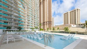 Un hôtel doté d’une piscine, de nombreux balcons et entouré d’immeubles de grande hauteur.