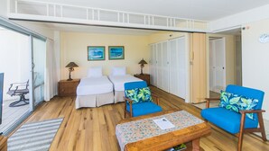 Een hotelkamer met twee bedden, een tafeltje, twee stoelen, een lamp en uitzicht naar buiten.