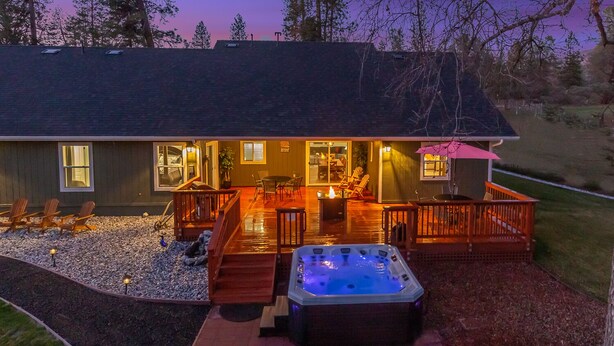 Une maison moderne dotée d’une terrasse, d’un jacuzzi et d’un espace salon extérieur.