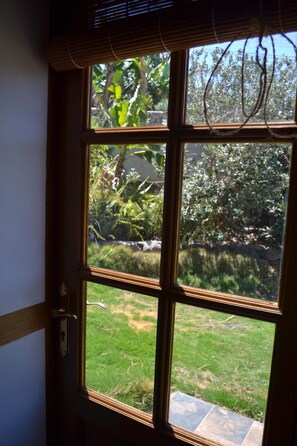 Enjoy a serene view of the garden from this room's window, overlooking lush greenery and a stone pathway.
