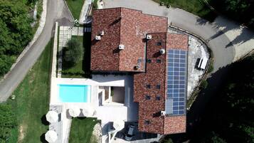 Um edifício residencial com piscina, painéis solares e gramado bem cuidado.