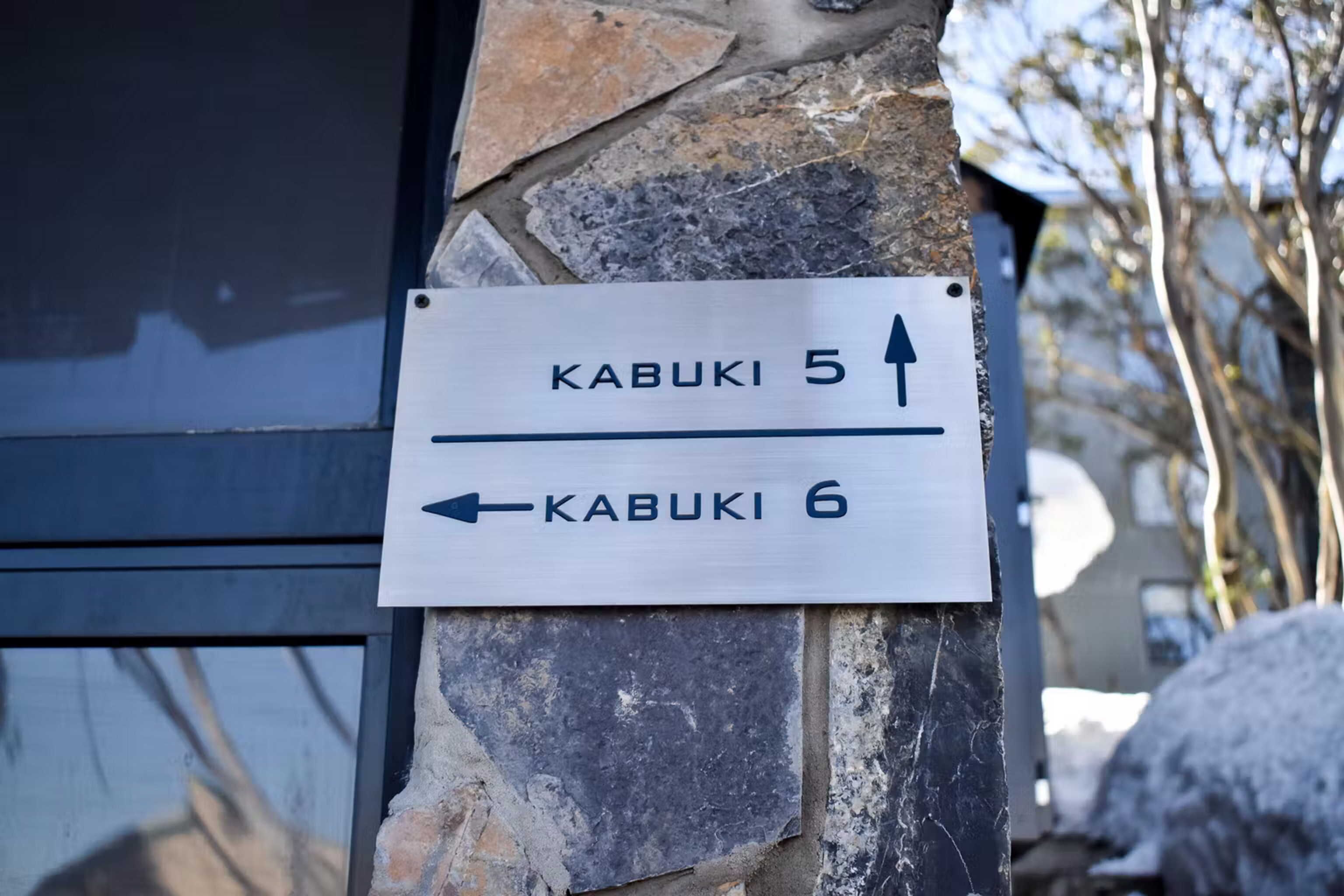 A directional sign on a stone wall indicating Kabuki 5 and Kabuki 6.
