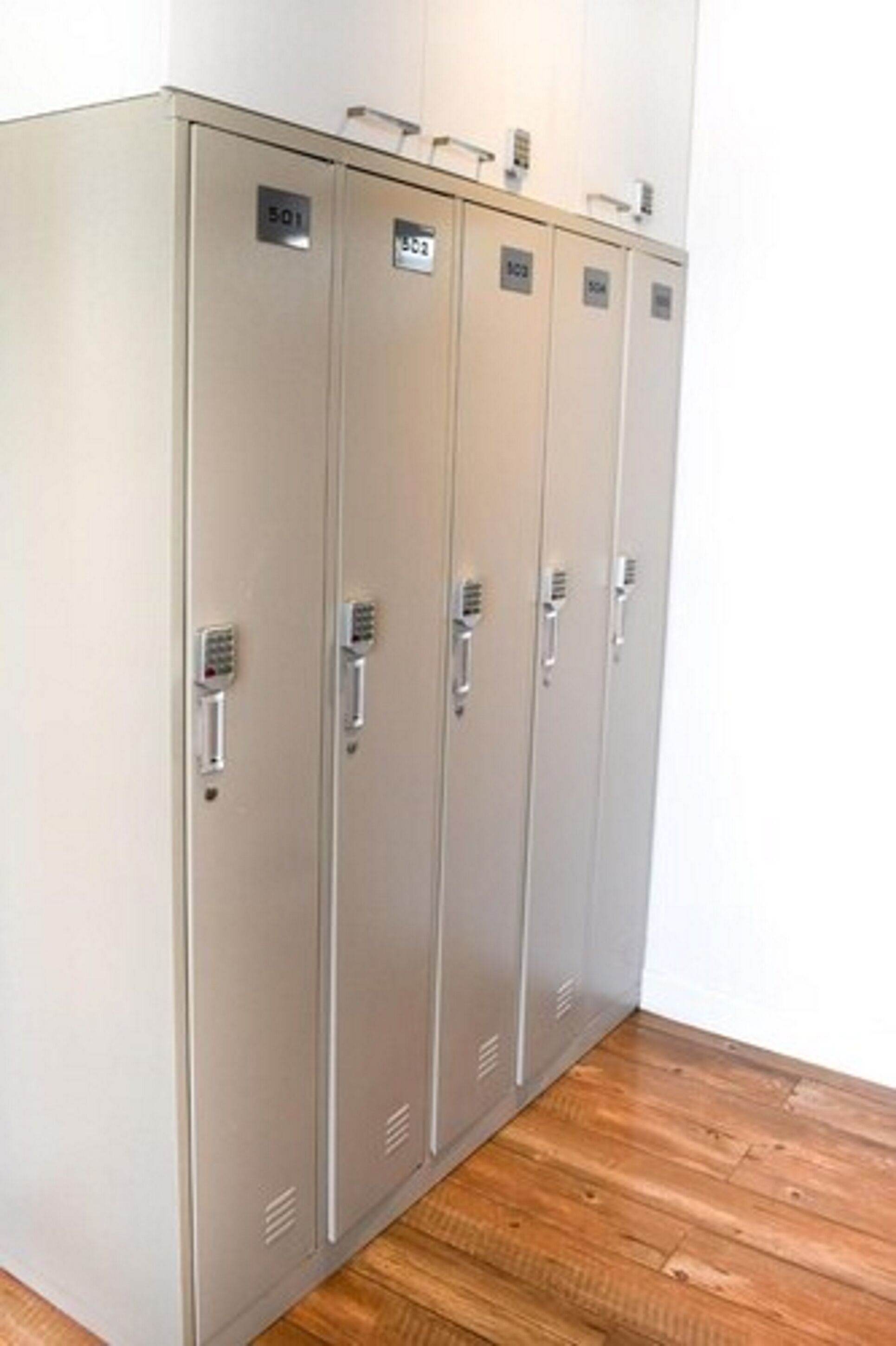 Een rij metalen lockers met genummerde sloten, waarschijnlijk voor spullen of persoonlijke bezittingen.