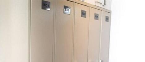 Een rij metalen lockers met genummerde sloten, waarschijnlijk voor spullen of persoonlijke bezittingen.