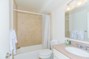Een badkamer met een bad, toilet en wastafel.