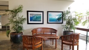 A lobby with a wooden bench, two potted plants, and two framed artworks on the wall. - Full Kitchen, Studio, Just Minutes to the Beach! (Honolulu)