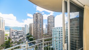 Un immeuble de grande hauteur doté de nombreux balcons et offrant une vue sur d’autres immeubles de grande hauteur en arrière-plan.