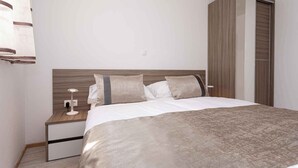 Un dormitorio con cama, mesita de noche, lámpara y armario.