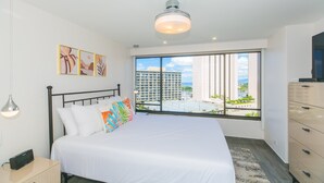 Une chambre d’hôtel moderne avec un grand lit, une vue sur la ville et un balcon.
