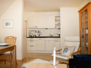 Un ambiente compatto con angolo ristoro, cucina e salotto.