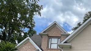 A two-story house with a brick facade, a black front door, and a garage. - "Lake Lanier Islands House Rental"  (Buford)