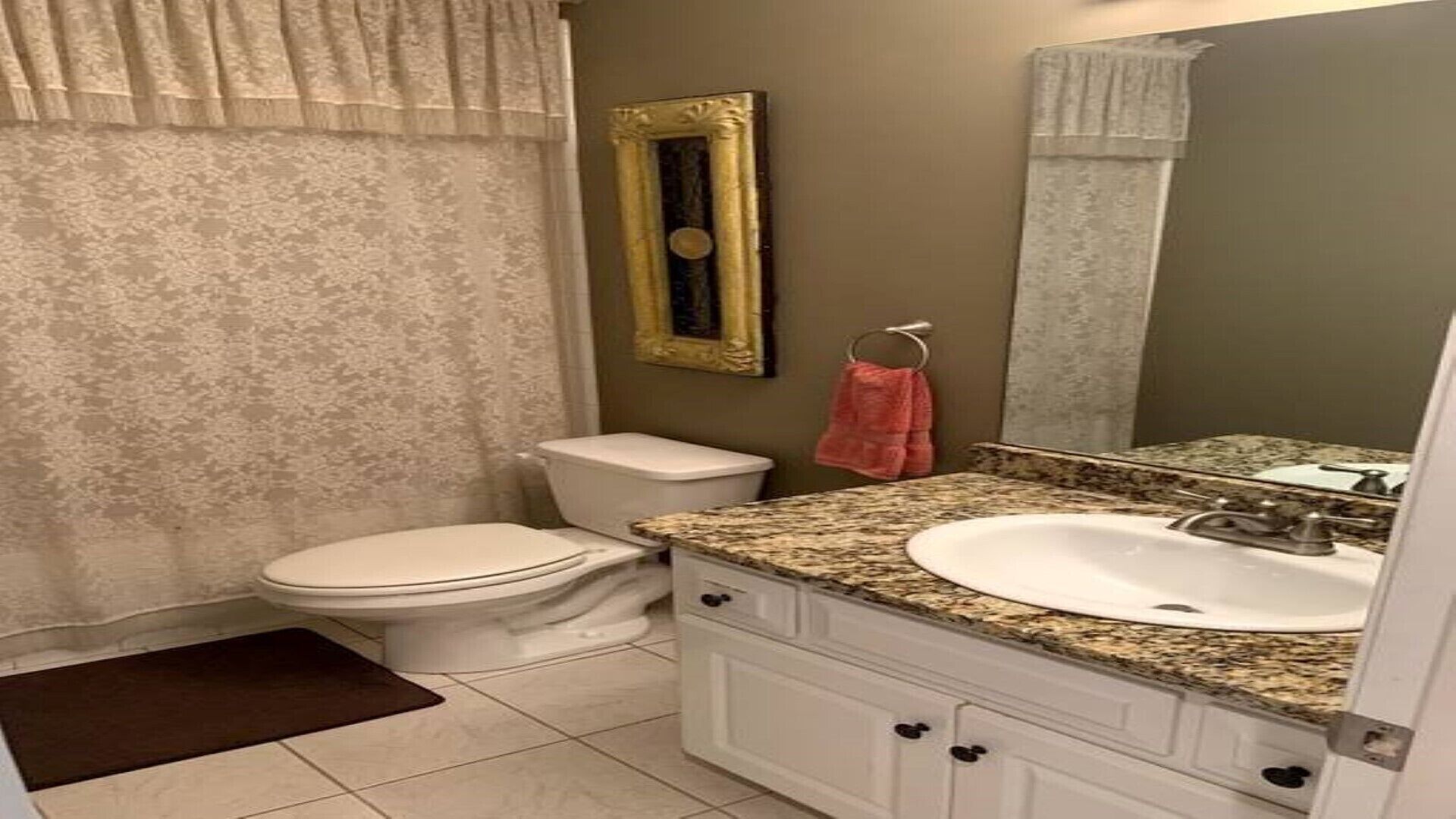 Un baño con inodoro, lavabo y espejo.