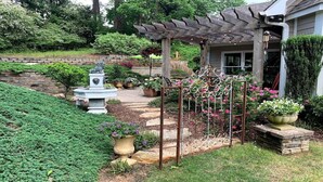 A garden with a pergola, a fountain, and potted plants. - "Lake Lanier Islands House Rental"  (Buford)