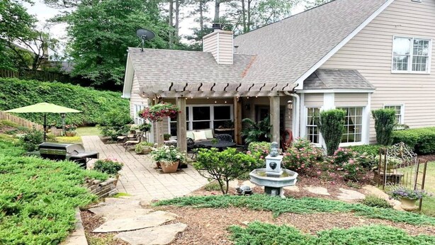 A house with a covered patio, outdoor seating, and a garden with a fountain. - "Lake Lanier Islands House Rental"  (Buford)
