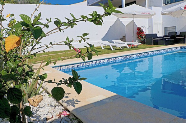 Relax by the serene pool surrounded by lush gardens and comfortable lounge chairs.