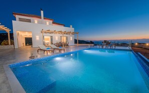 A modern villa with a swimming pool, outdoor seating, and a view of the landscape. - DaLuz Villa, lighthouse villa with private pool and sea view (Zakynthos)