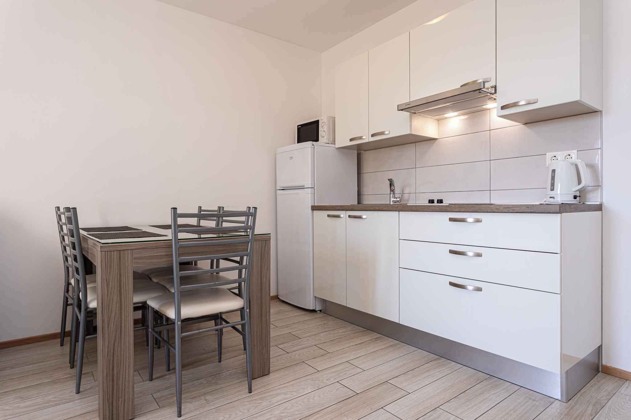 A compact kitchen with white cabinets, a built-in microwave, and a coffee maker.