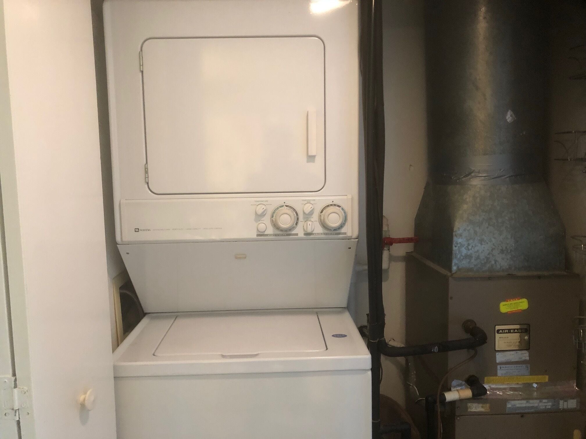 A compact, white washer and dryer unit with a control panel featuring three knobs and a small display.