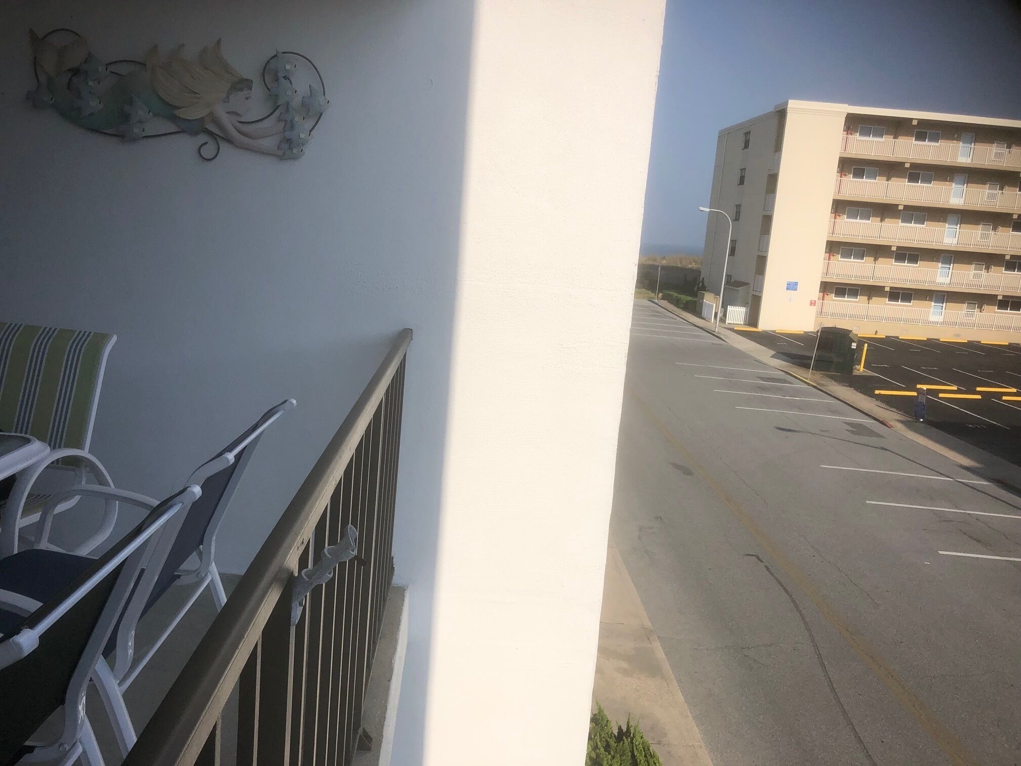 Ein Balkon mit Metallgeländern und einem Stuhl.