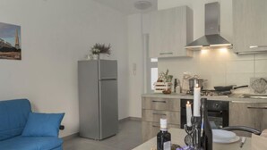 Een moderne keuken met een inbouwfornuis, een koelkast en houten keukenkastjes.