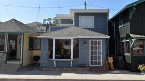 Une petite maison de plain-pied, dotée d’un toit à pignon et d’un porche à l’avant.