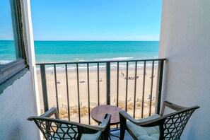 Un balcon avec vue sur une plage et l’océan.