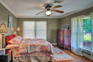 A bedroom with a bed, a ceiling fan, a dresser, and a window with curtains. - Secluded Baton Rouge Area Hideaway w/ Lawn! (Clinton)