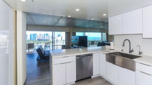 Una cocina moderna con una isla grande, electrodomésticos de acero inoxidable y vistas a la ciudad.