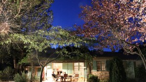 Una casa con porche cubierto, zona de comedor y jardín visible.