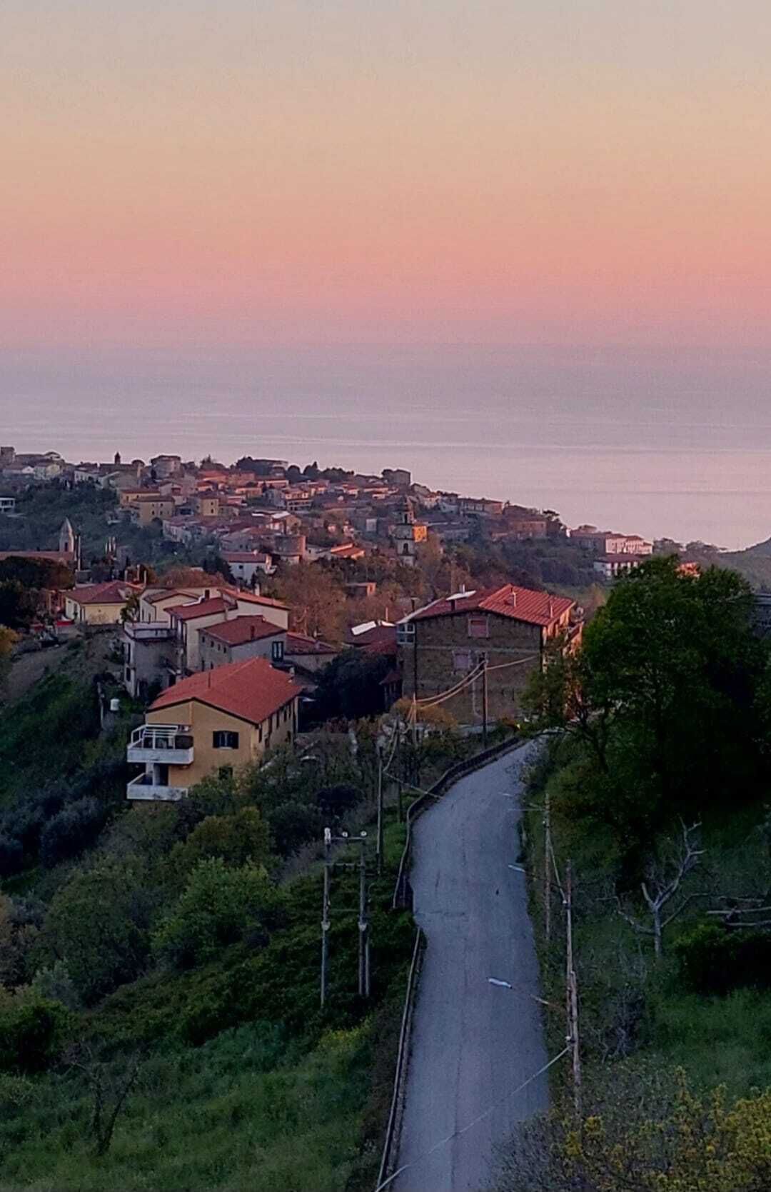Une ville côtière avec une route sinueuse, des bâtiments et une église.