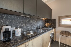 A kitchen with a marble countertop, stainless steel sink, and modern appliances including a coffee maker and a slow cooker. - Luxurious Holiday Home with Pool, Terrace, Wi-Fi & Air Conditioning; Parking Available, Smaller Pets Allowed (domus de maria)