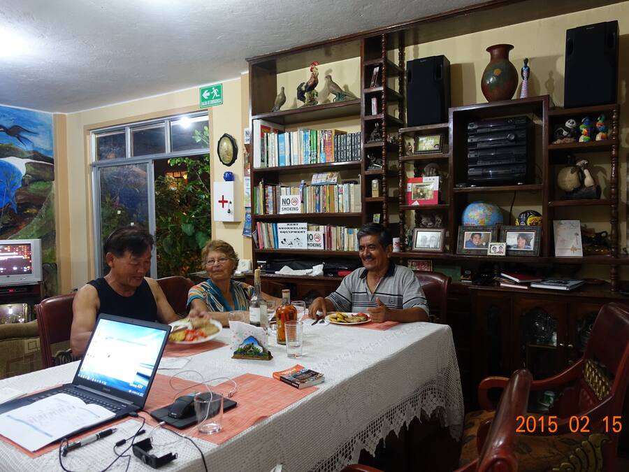 A room with a dining table, chairs, a laptop, books, and decorative items.