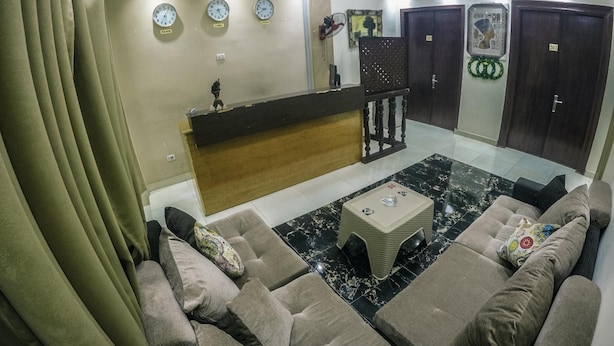 A modern living room with a sofa set, a coffee table, and a reception desk. - New City Hotel (Cairo)