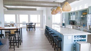 A modern kitchen with a central island, bar stools, and pendant lighting. - BEACHFRONT on 1 acre lot with incredible beach and bay views.  (Freeport)