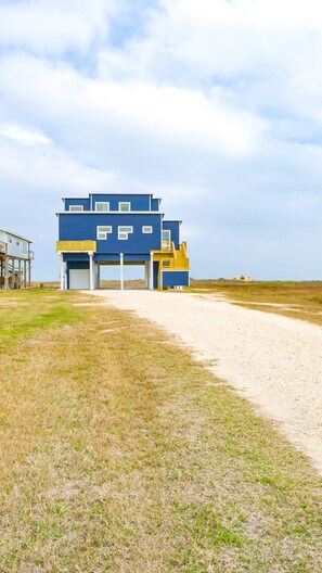 Un edificio moderno azul con varios niveles y una escalera amarilla.