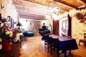 Un intérieur rustique comprenant un coin repas, des canapés et une cheminée.