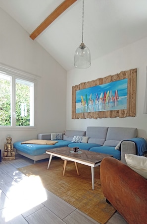 A living room with a blue sofa, a wooden coffee table, and a Buddha statue.