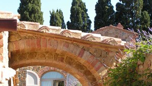 An arched stone bridge with a stone building in the background.