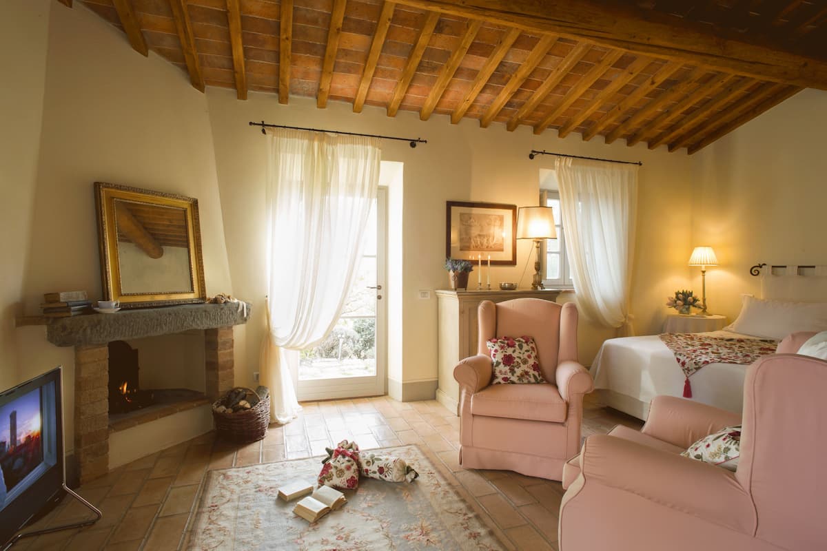 Une pièce chaleureuse avec une cheminée, un canapé confortable, un lit et un téléviseur.