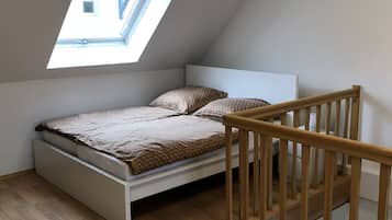 Ein Einzelbett mit Holzvorzelt und einem Oberlicht darüber.