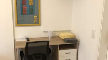 A small office space with a desk, chair, and a mounted TV.