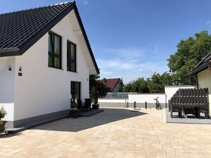 A modern house with a tiled roof, a covered patio area, and a visible number '92a' on the wall. - Gästehaus Witteborg (Paderborn)