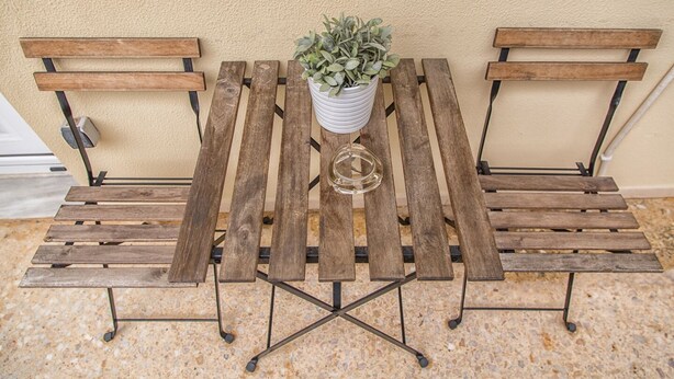 A wooden bench with a potted plant in the center. - Margarita's home cozy home! (Athina)
