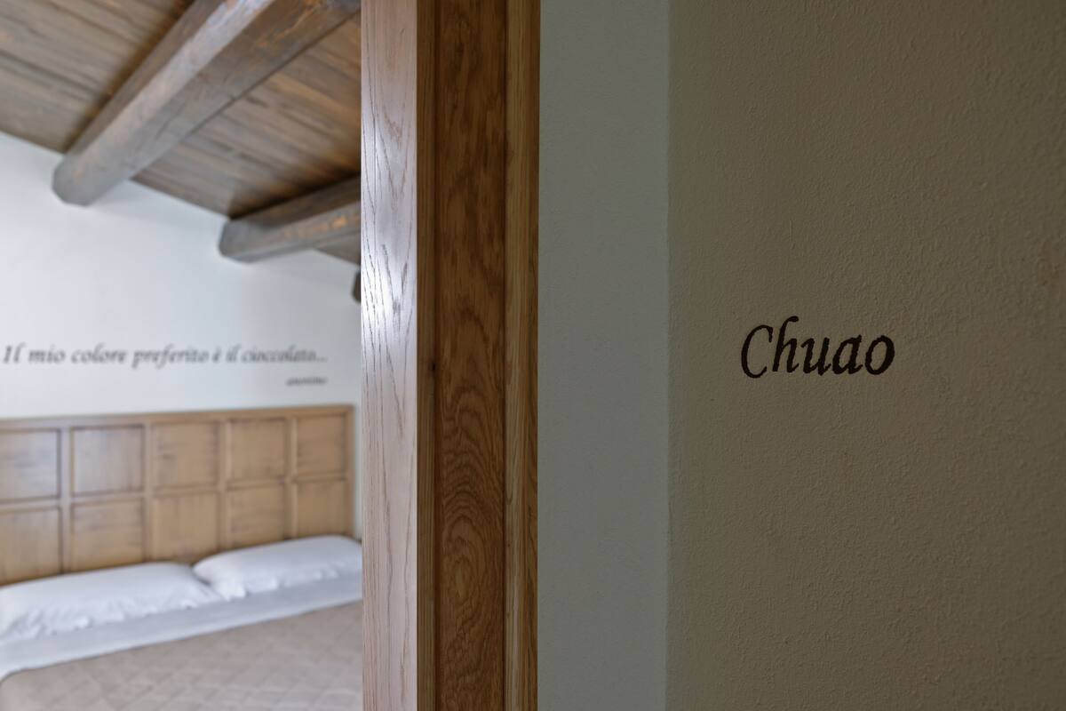 Marco de madera de una puerta y una pared con el nombre "Chuao" escrito.