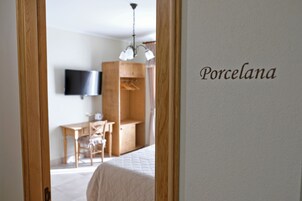 Un dormitorio con cama, escritorio, silla, televisor y armario.