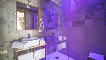 A bathroom with a white sink, a mirror, and a shower with a glass door.